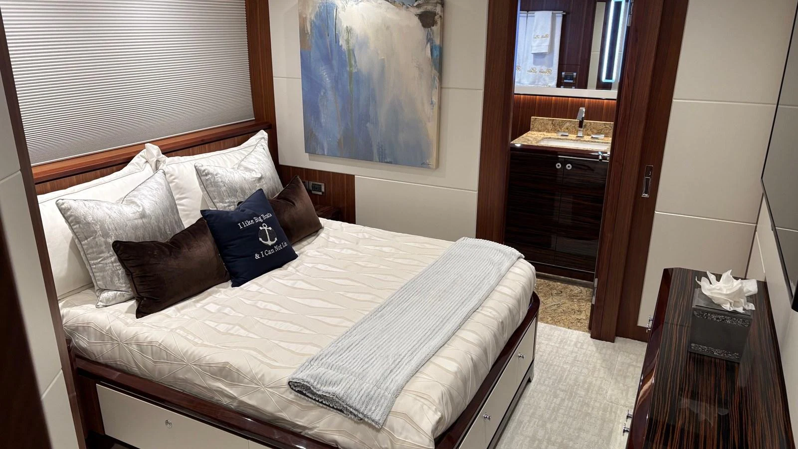 A luxurious stateroom featuring a comfortable bed with plush pillows and a view into an elegant ensuite bathroom. aboard BELLA LISA Yacht for Sale