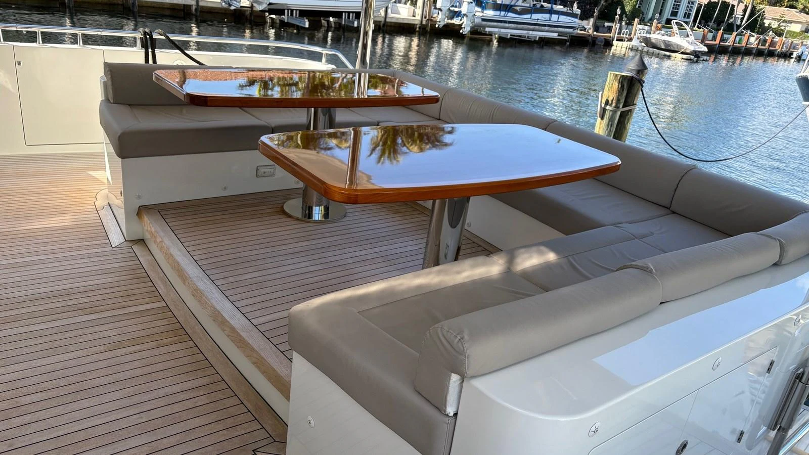 The aft deck features elegant seating and polished wooden tables, perfect for alfresco dining. aboard BELLA LISA Yacht for Sale