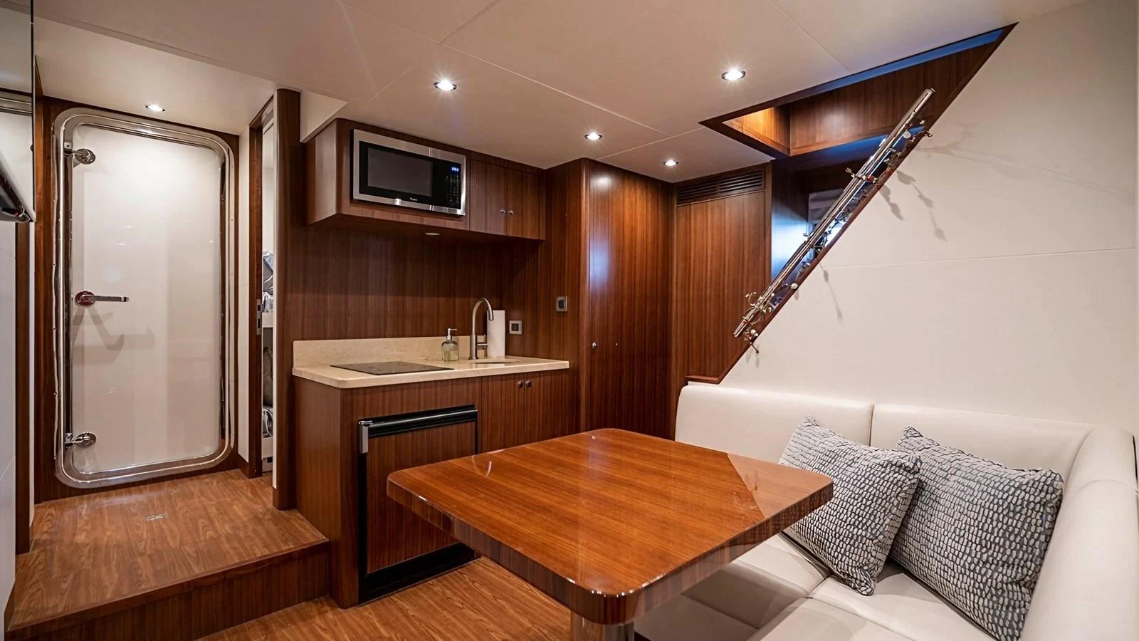 The yacht's galley features a cozy dining area with a wooden table and a compact kitchen setup. aboard BELLA LISA Yacht for Sale
