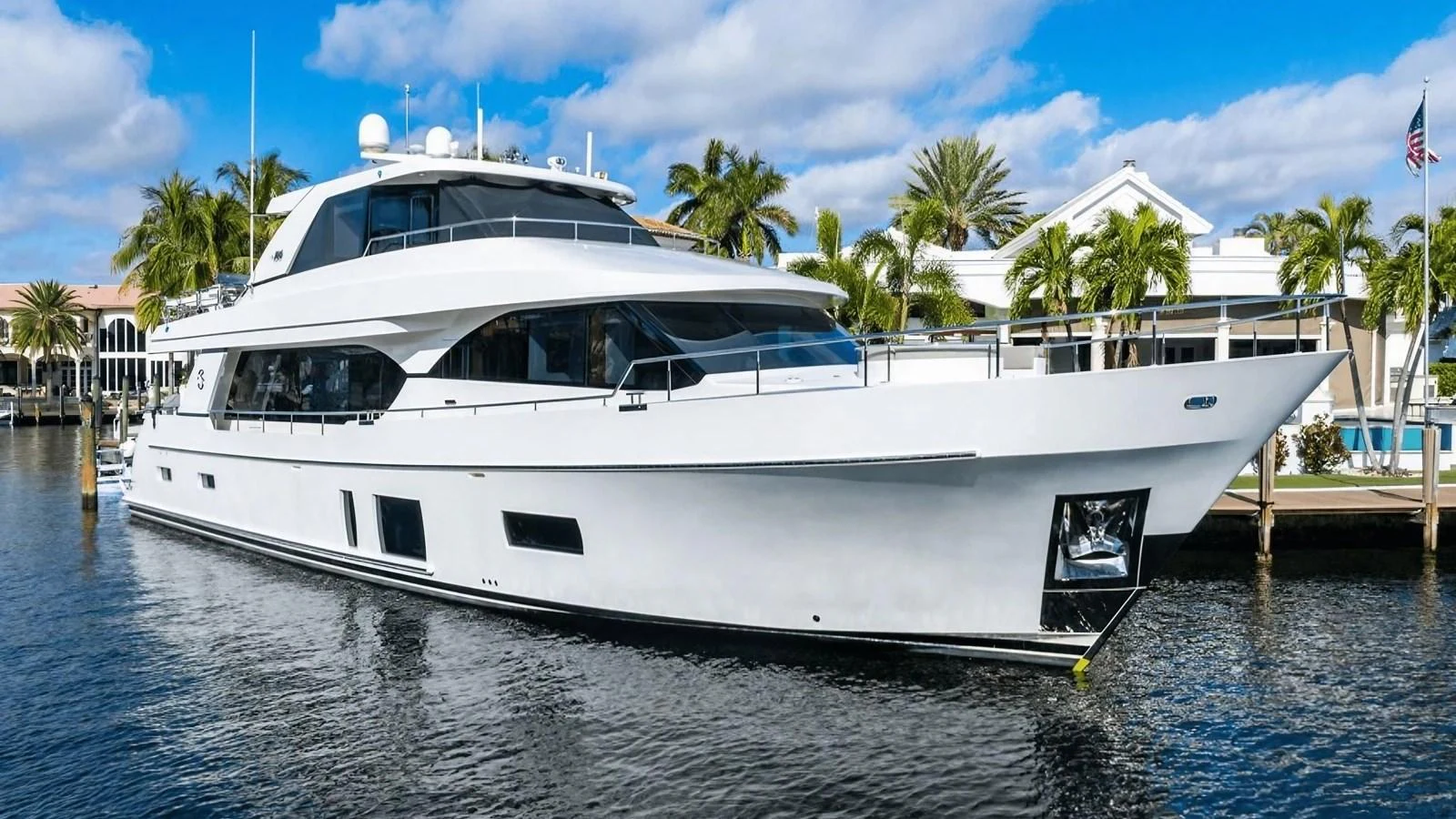 A sleek and modern yacht is docked in a serene marina with palm trees in the background. aboard BELLA LISA Yacht for Sale