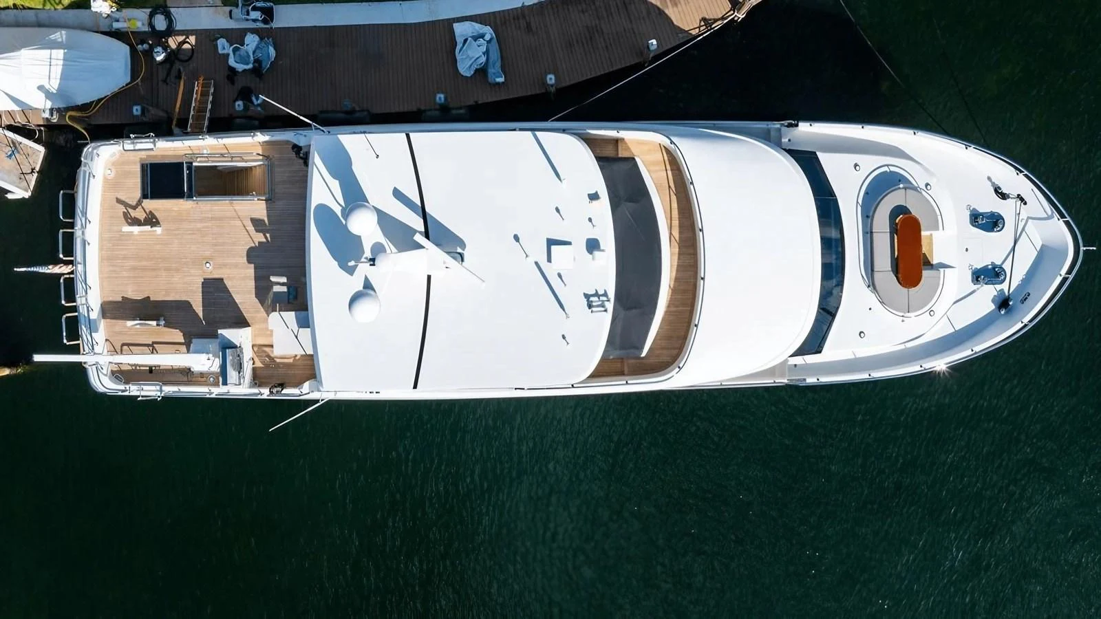 An aerial view of a sleek yacht docked at a marina, showcasing its spacious deck and elegant design. aboard BELLA LISA Yacht for Sale