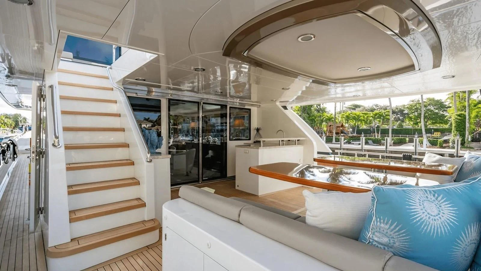 The aft deck features a comfortable seating area with plush cushions and a staircase leading to the upper deck. aboard BELLA LISA Yacht for Sale
