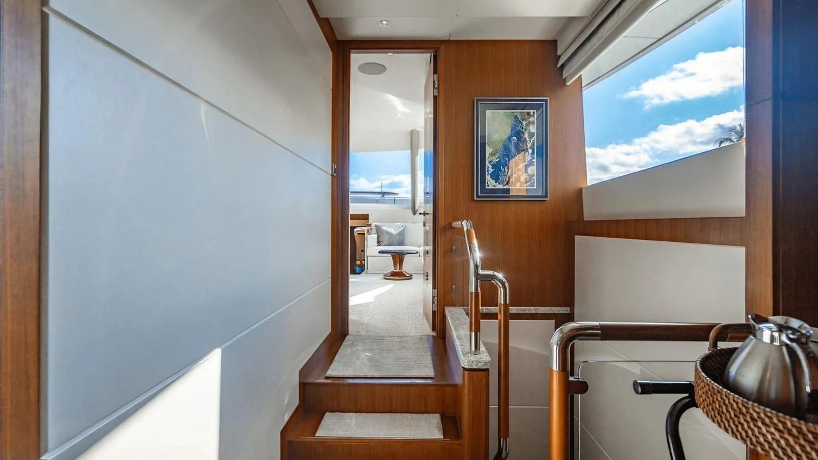 A beautifully lit interior hallway leading to a cozy seating area with a large window view. aboard BELLA LISA Yacht for Sale