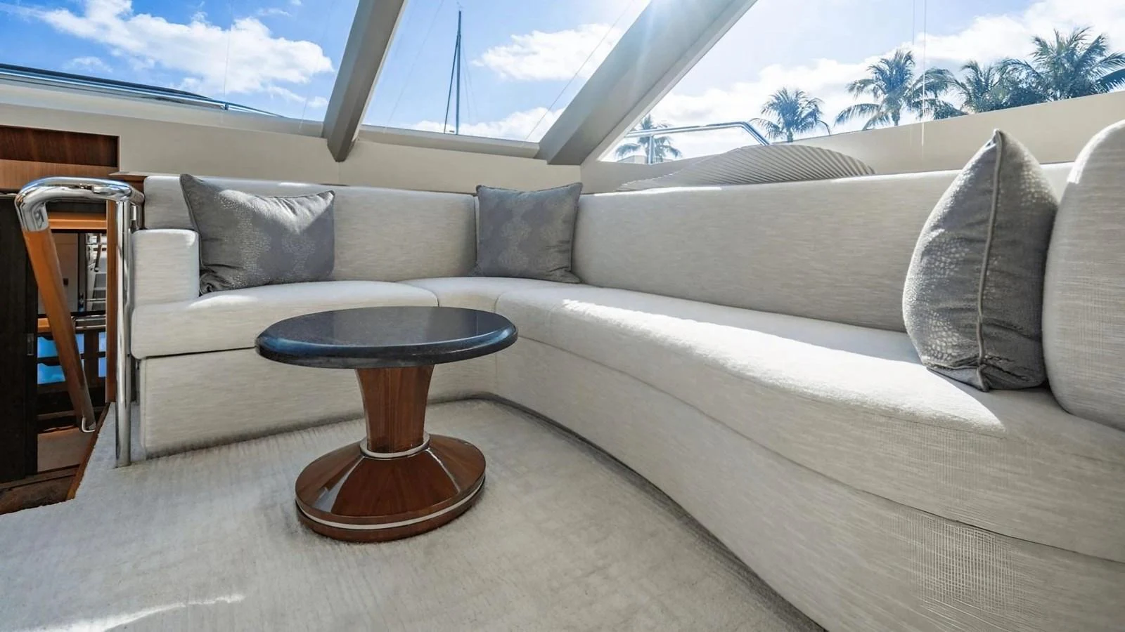 The salon features a plush, curved sofa with a sleek coffee table, bathed in natural light from large windows. aboard BELLA LISA Yacht for Sale