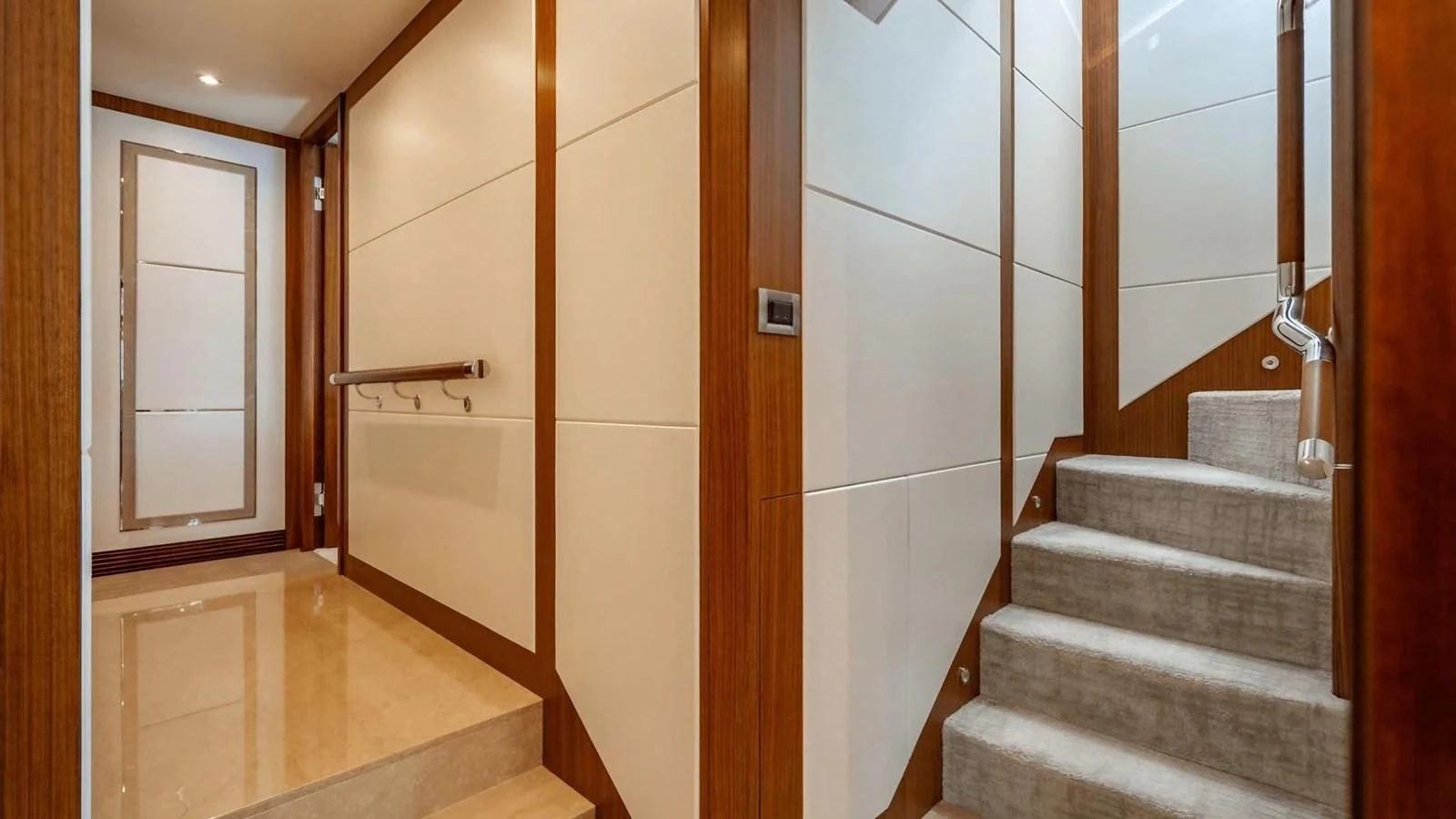 The yacht's interior features a modern staircase with elegant wood and neutral tones. aboard BELLA LISA Yacht for Sale