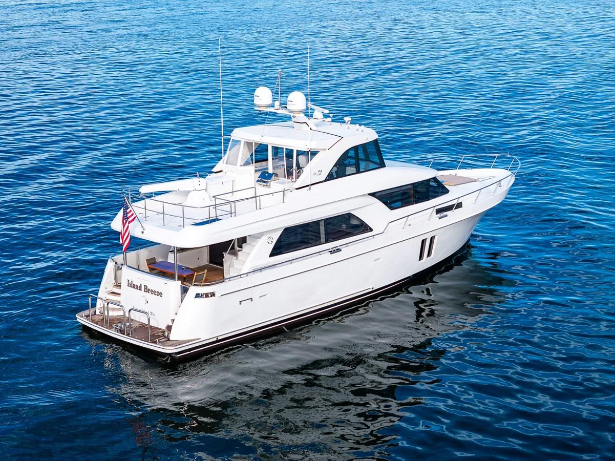 A sleek white yacht glides gracefully on calm blue waters, showcasing its elegant design and spacious decks. aboard ISLAND BREEZE Yacht for Sale
