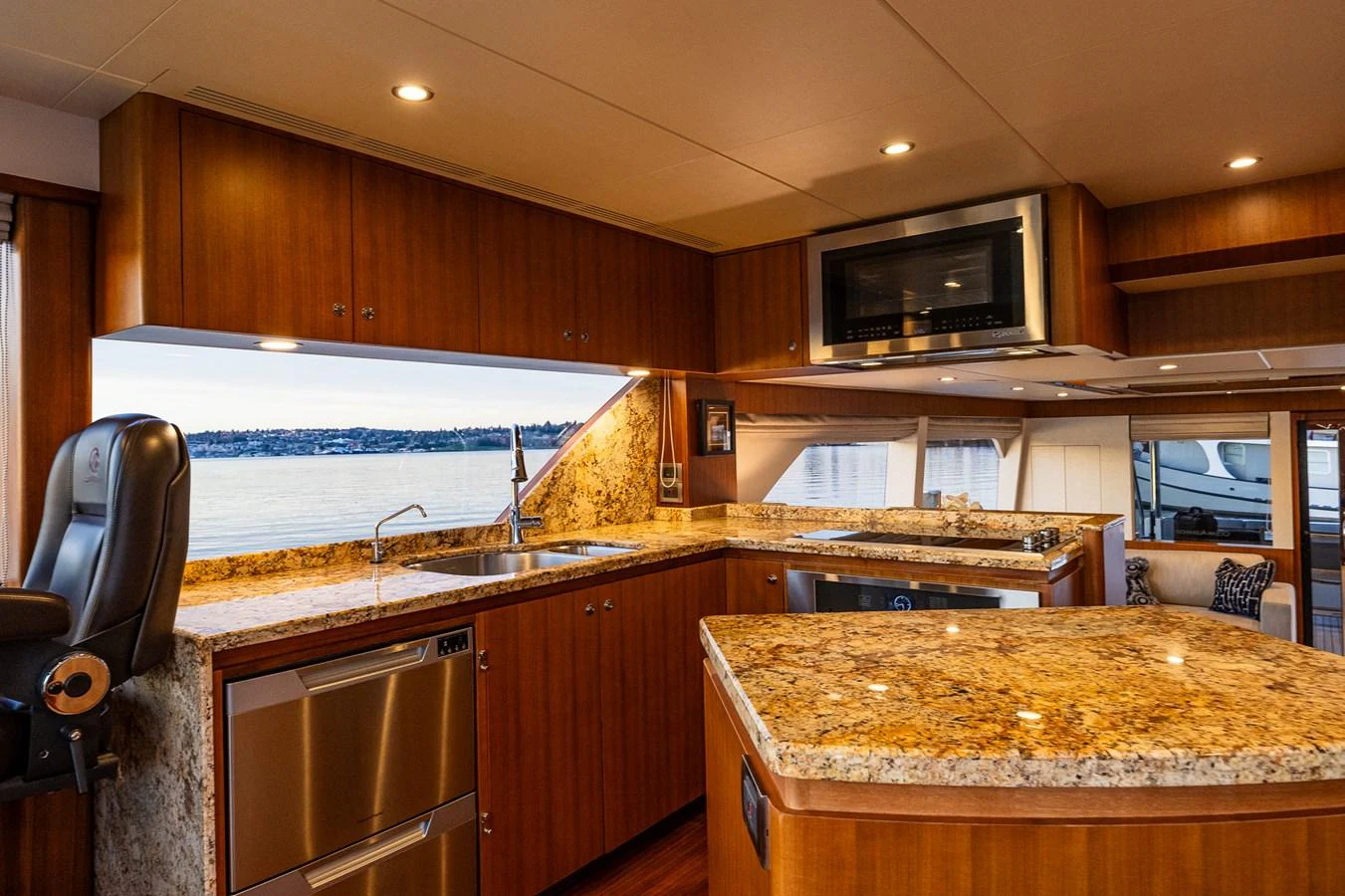 The yacht's galley features elegant wood cabinetry and granite countertops with a scenic view through the windows. aboard ISLAND BREEZE Yacht for Sale