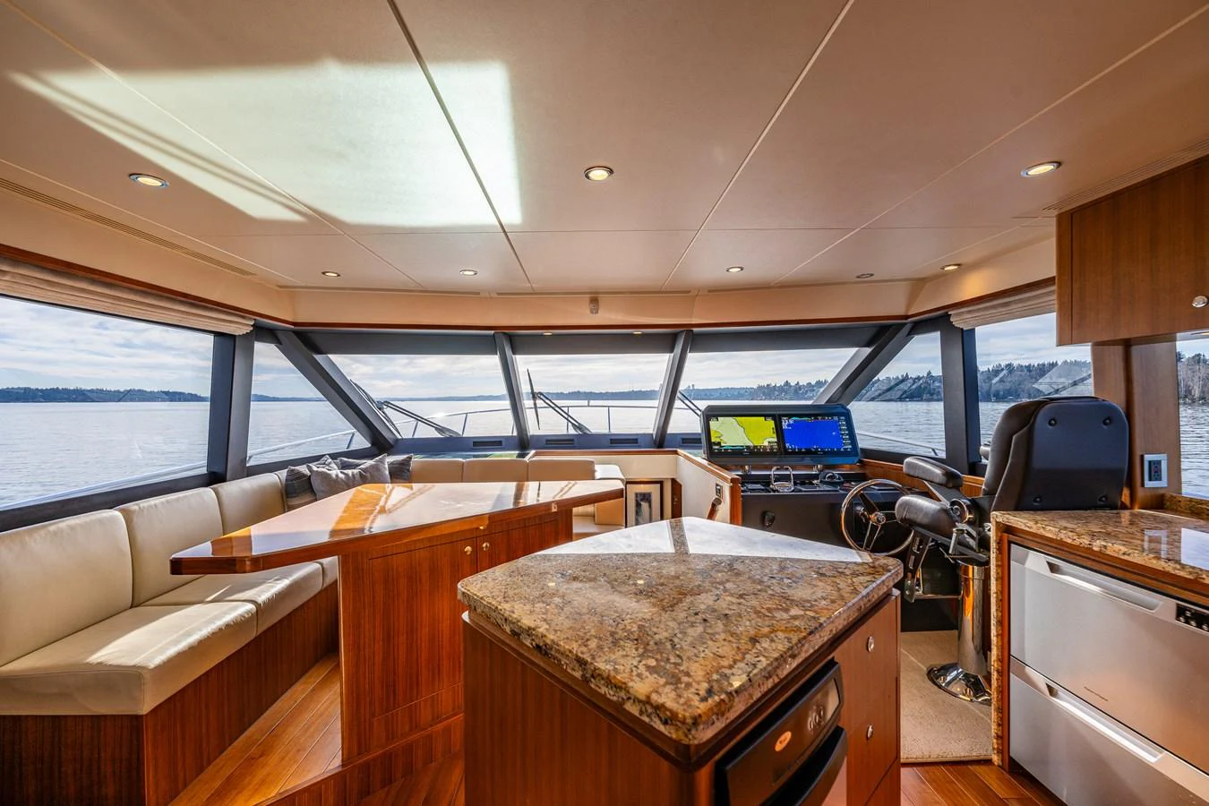 The helm area features luxurious wood finishes, a spacious seating area, and state-of-the-art navigation equipment. aboard ISLAND BREEZE Yacht for Sale