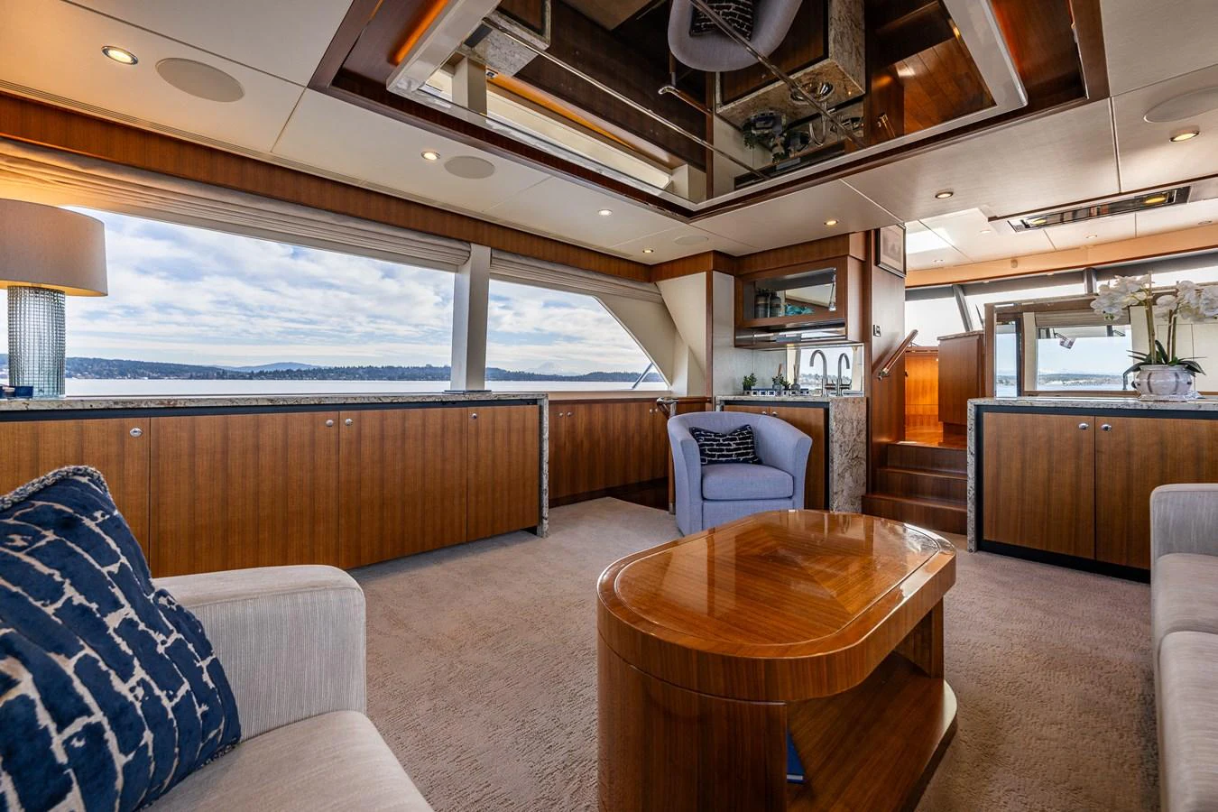 The yacht's salon features elegant wood finishes, plush seating, and expansive windows offering stunning ocean views. aboard ISLAND BREEZE Yacht for Sale