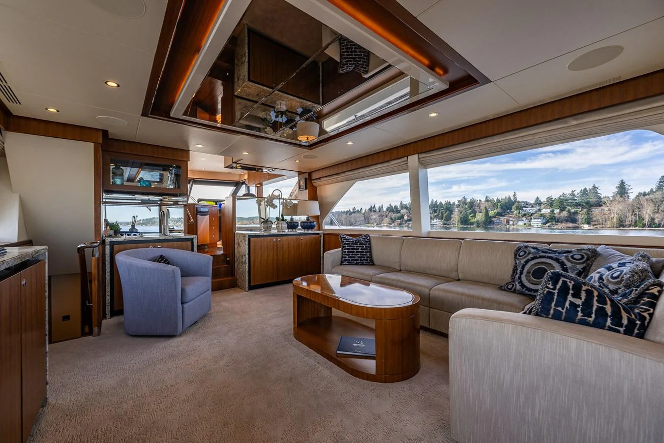 The salon features plush seating, a coffee table, and large windows offering panoramic views. aboard ISLAND BREEZE Yacht for Sale