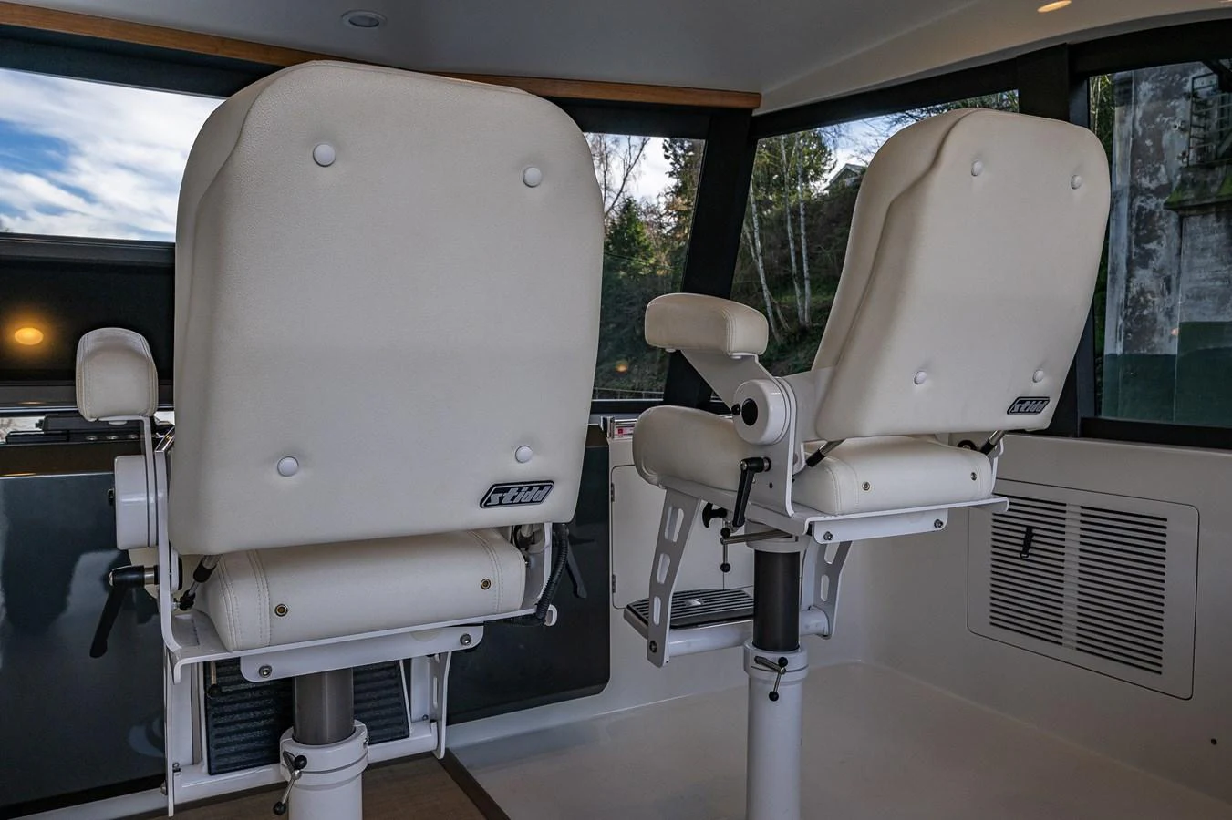 The helm features two luxurious white captain's chairs with a view of the surrounding scenery. aboard ISLAND BREEZE Yacht for Sale