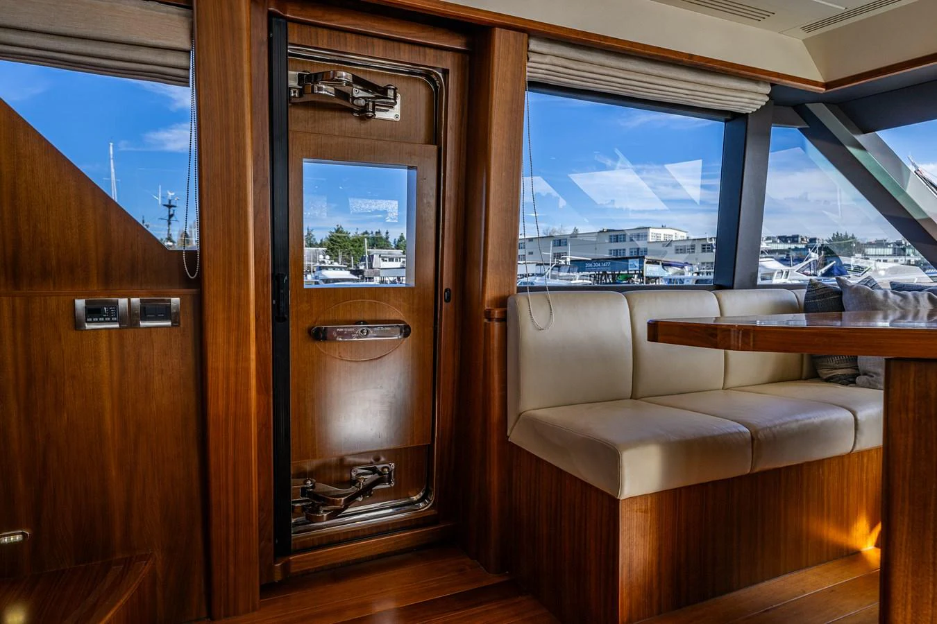 The yacht's interior features a cozy seating area with a view of the marina through large windows. aboard ISLAND BREEZE Yacht for Sale