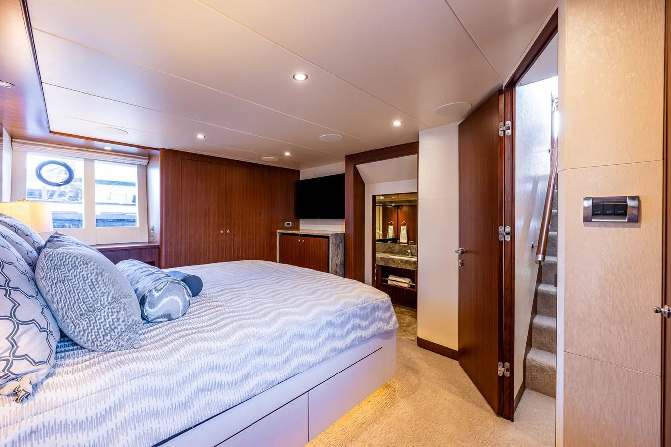 The stateroom features a plush bed, wooden accents, and modern amenities for a luxurious stay. aboard ISLAND BREEZE Yacht for Sale