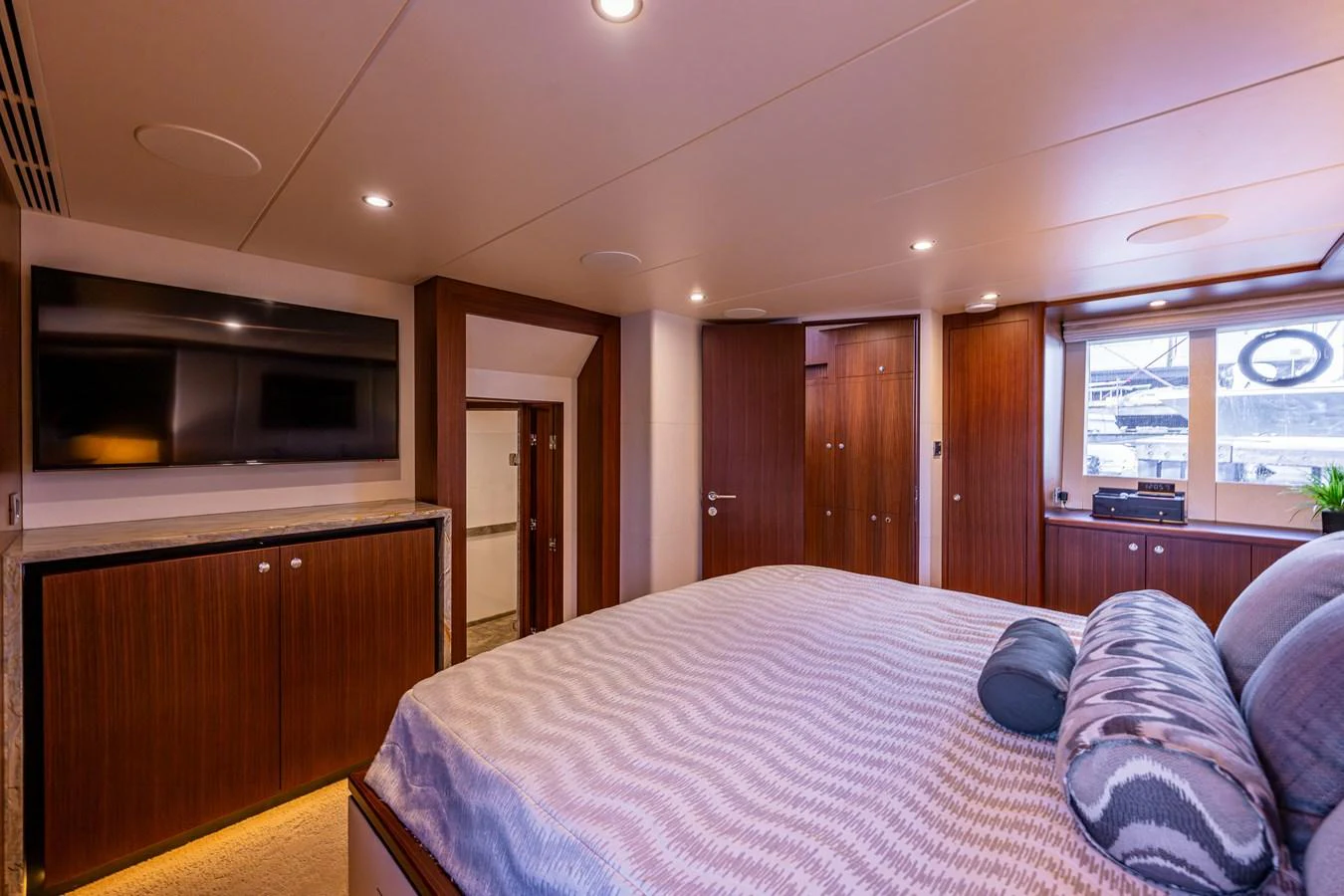 The master stateroom features a luxurious bed, wood paneling, and modern amenities for ultimate comfort. aboard ISLAND BREEZE Yacht for Sale