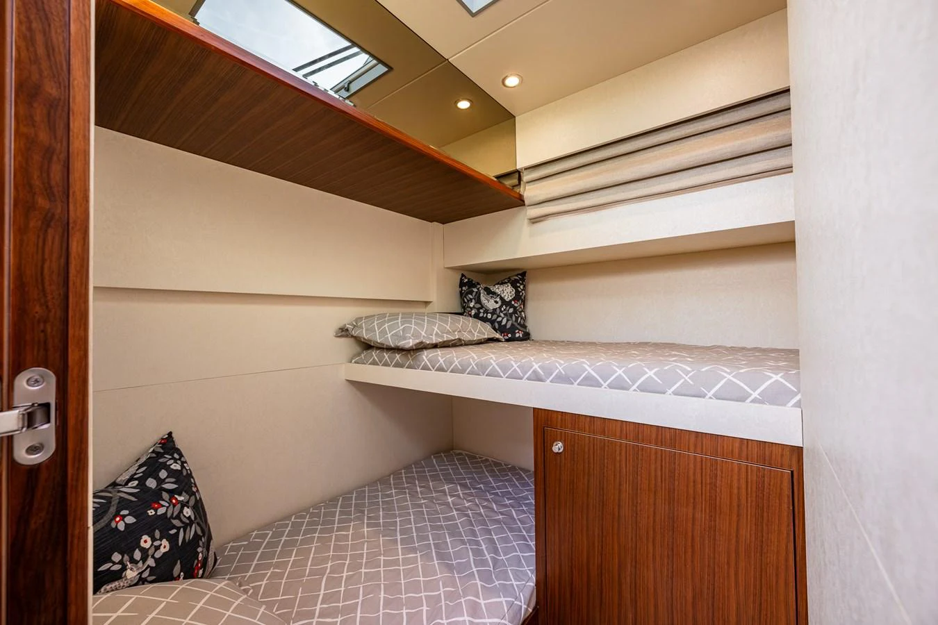 A cozy cabin with bunk beds and modern wooden finishes. aboard ISLAND BREEZE Yacht for Sale