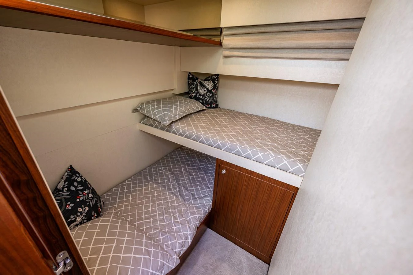 A cozy cabin with twin bunk beds and patterned pillows. aboard ISLAND BREEZE Yacht for Sale