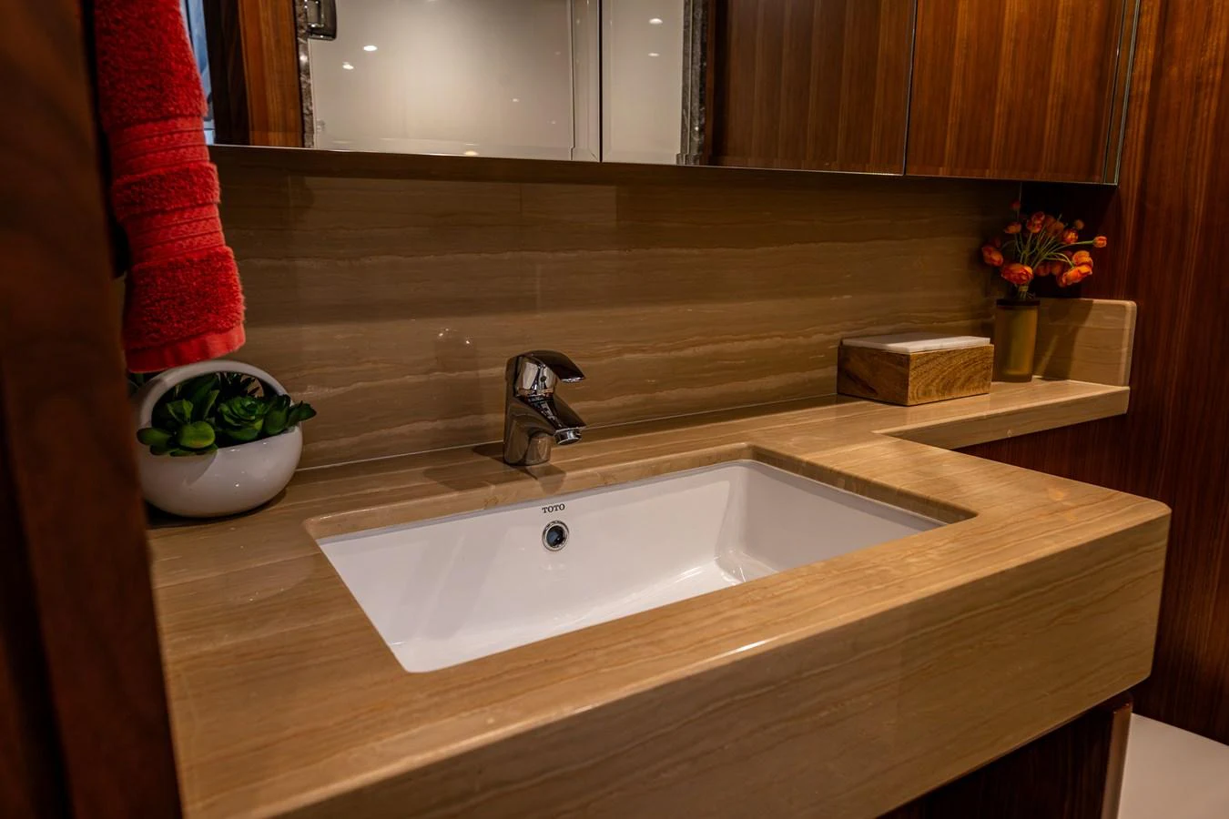 The yacht's bathroom features a sleek sink with elegant wooden accents and modern fixtures. aboard ISLAND BREEZE Yacht for Sale
