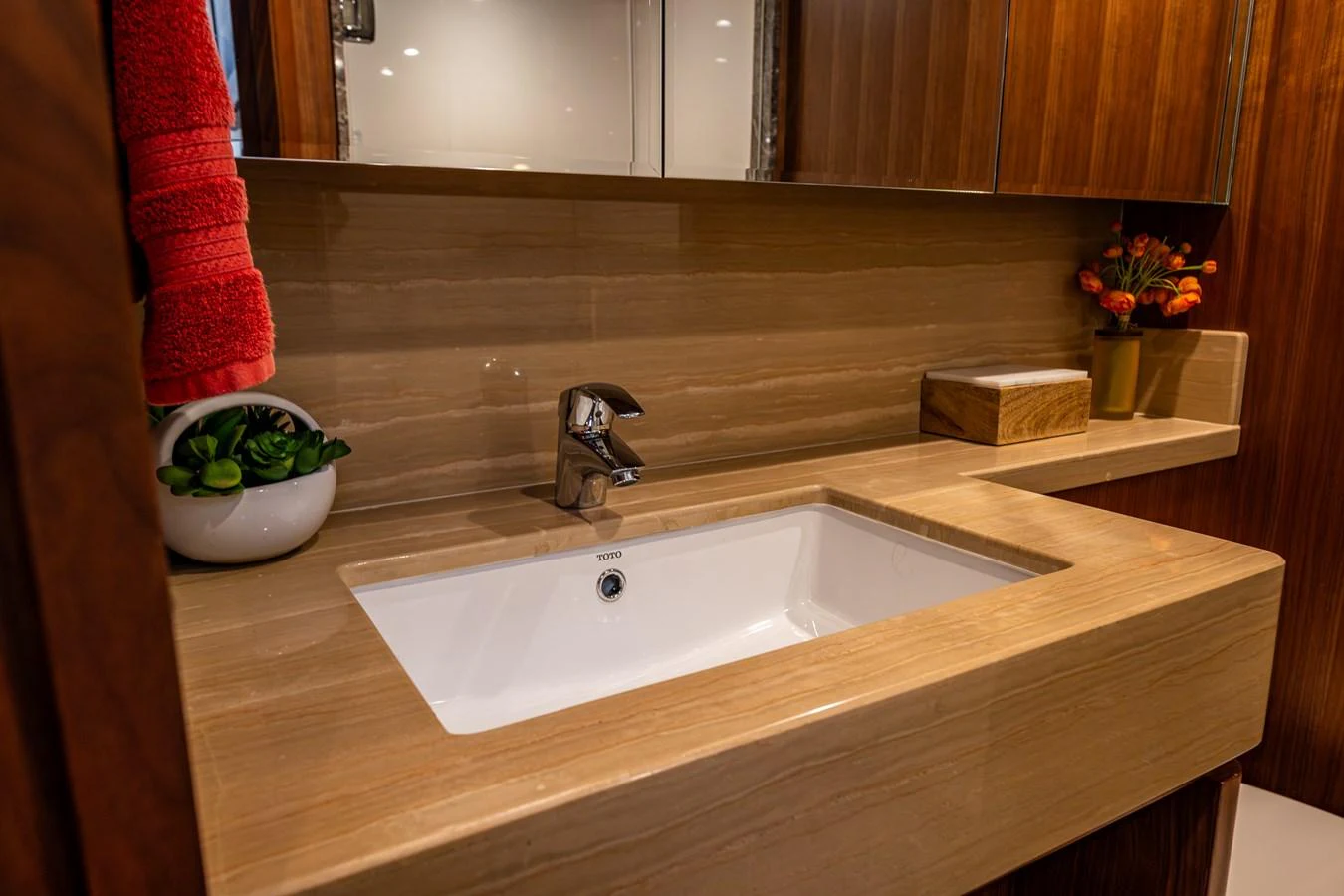 The yacht's bathroom features a sleek sink area with elegant wooden accents and modern fixtures. aboard ISLAND BREEZE Yacht for Sale