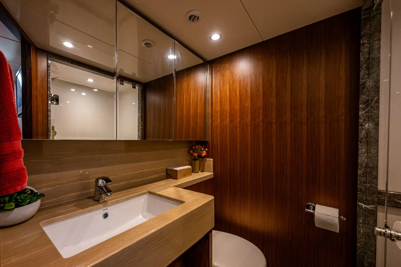 The bathroom features elegant wood paneling and modern fixtures, creating a warm and inviting atmosphere. aboard ISLAND BREEZE Yacht for Sale