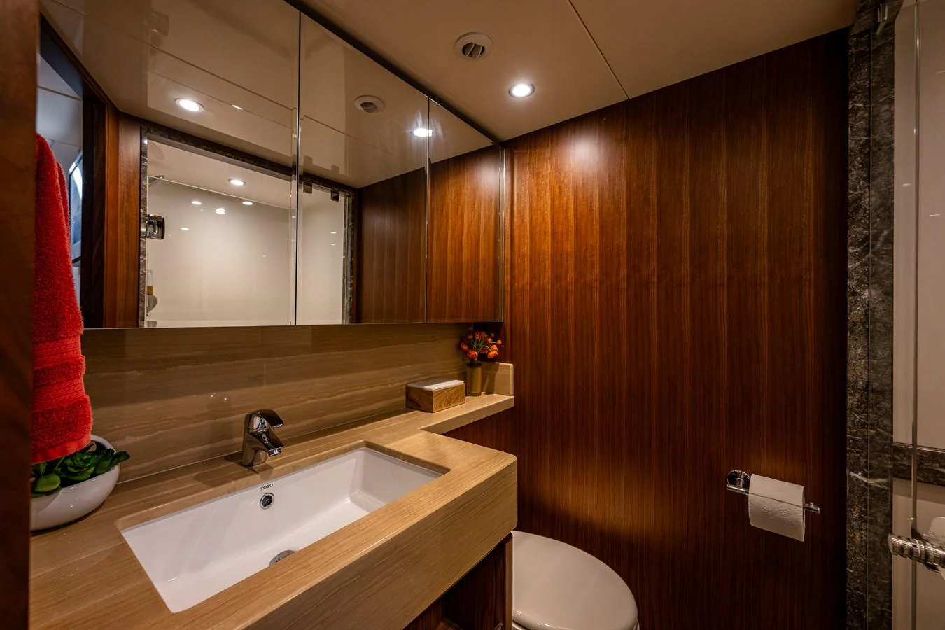 The yacht's bathroom features sleek wood paneling and modern fixtures, creating a warm and inviting atmosphere. aboard ISLAND BREEZE Yacht for Sale