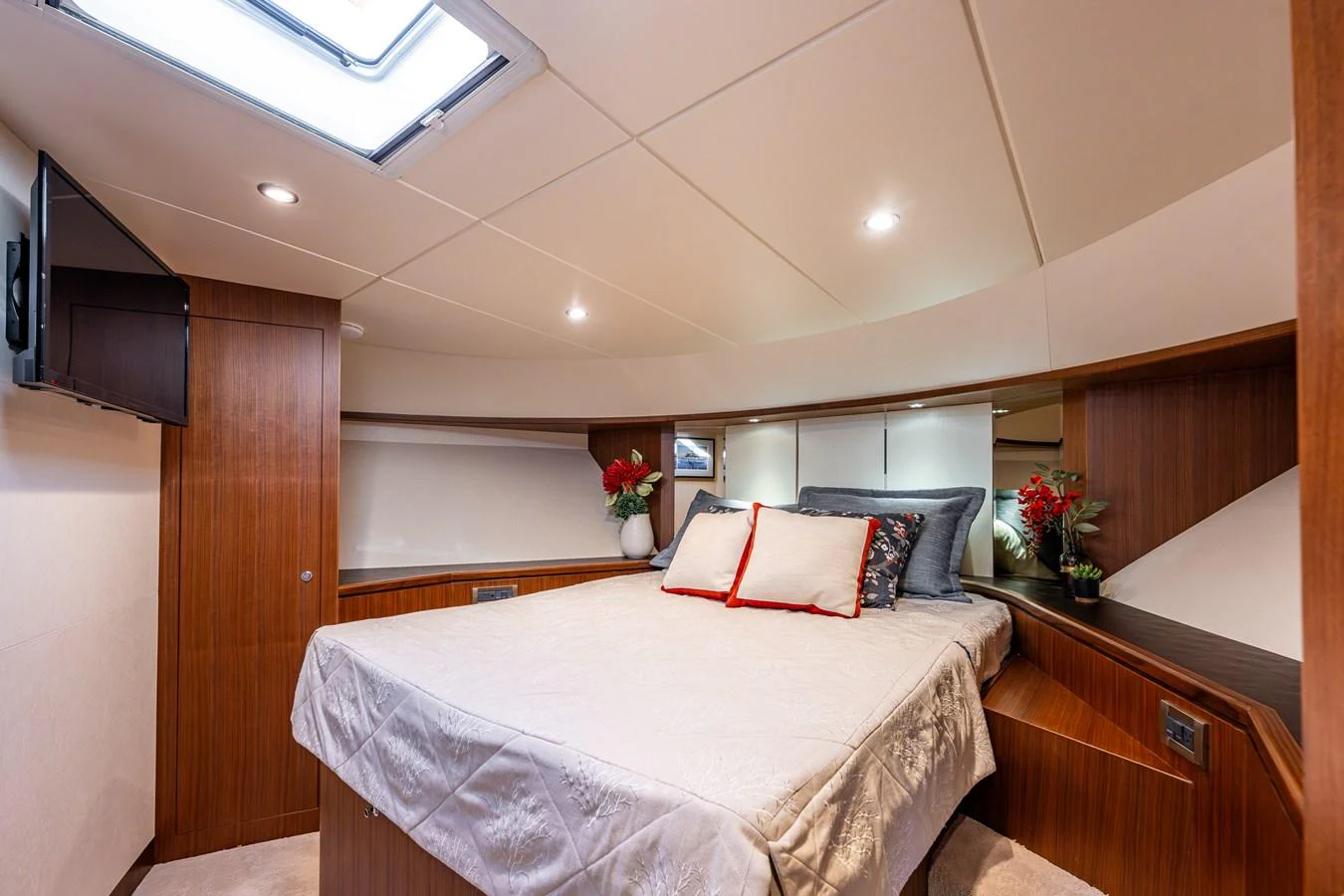 The stateroom features a cozy bed with elegant bedding and warm wooden finishes. aboard ISLAND BREEZE Yacht for Sale