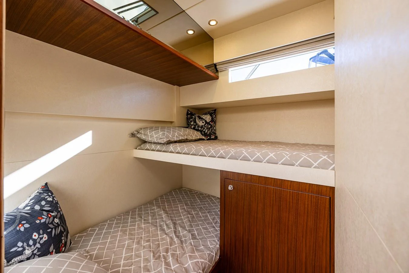 The cozy guest cabin features comfortable twin bunk beds with stylish bedding and ample natural light. aboard ISLAND BREEZE Yacht for Sale