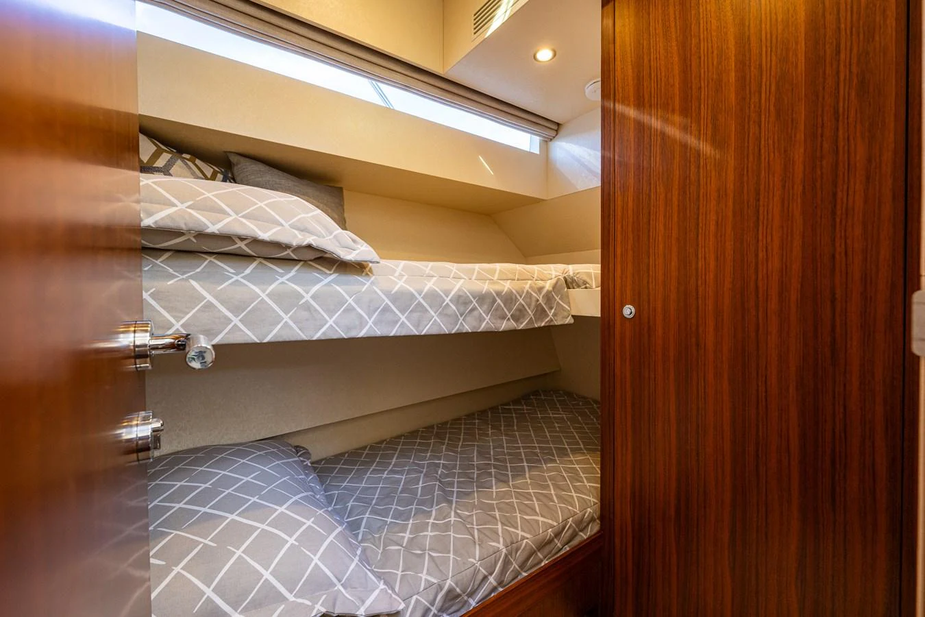 The cozy guest cabin features comfortable bunk beds with stylish bedding. aboard ISLAND BREEZE Yacht for Sale