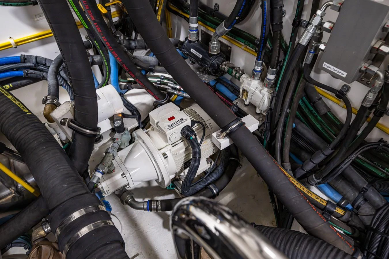 A close-up view of the yacht's engine room showcasing various mechanical components and hoses. aboard ISLAND BREEZE Yacht for Sale