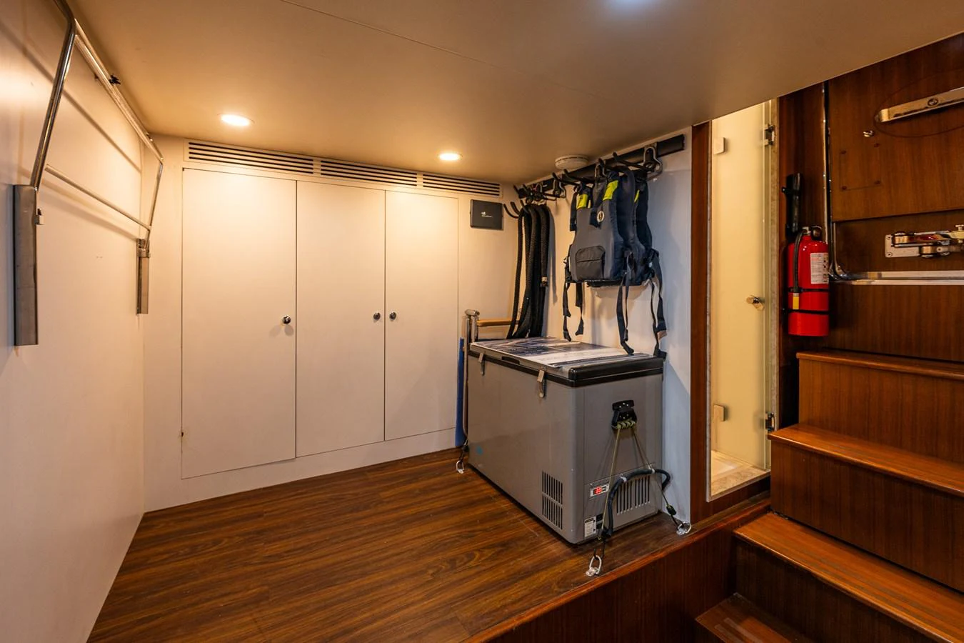 This image showcases a practical interior space with storage cabinets and safety equipment. aboard ISLAND BREEZE Yacht for Sale