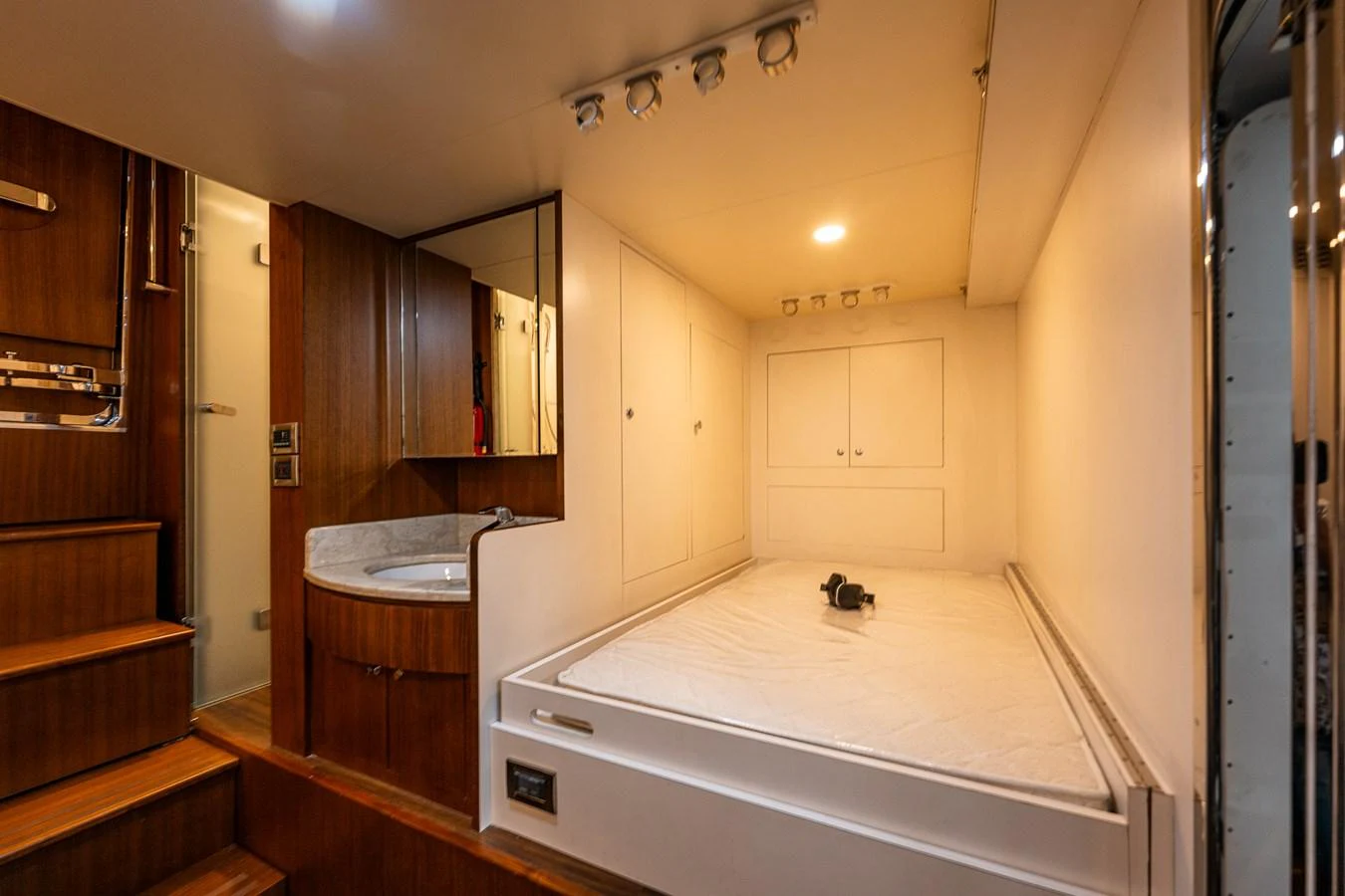 The cozy stateroom features a comfortable bed, wooden accents, and modern lighting. aboard ISLAND BREEZE Yacht for Sale