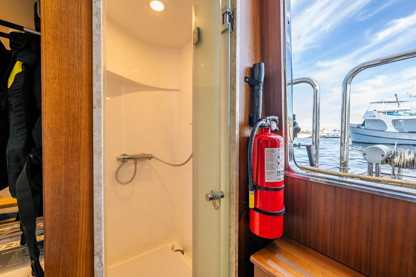 A compact yacht shower area with a view of the marina through the window. aboard ISLAND BREEZE Yacht for Sale