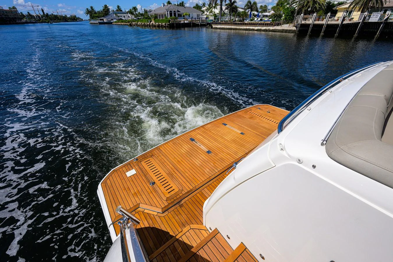The yacht's aft deck features elegant teak flooring and offers a stunning view of the water and shoreline. aboard MISS AMY Yacht for Sale
