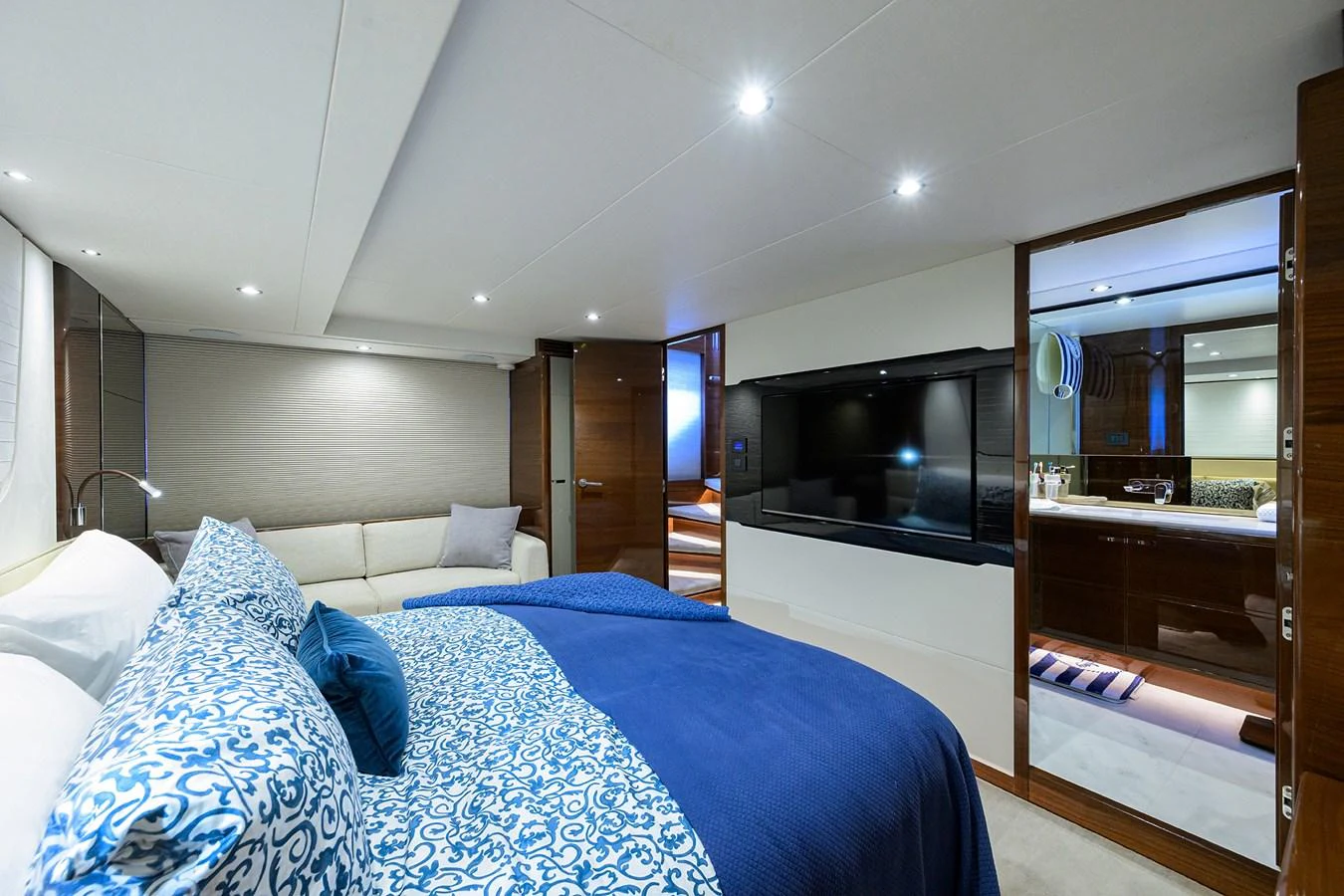 A luxurious stateroom featuring a plush bed with blue accents and modern amenities. aboard MISS AMY Yacht for Sale