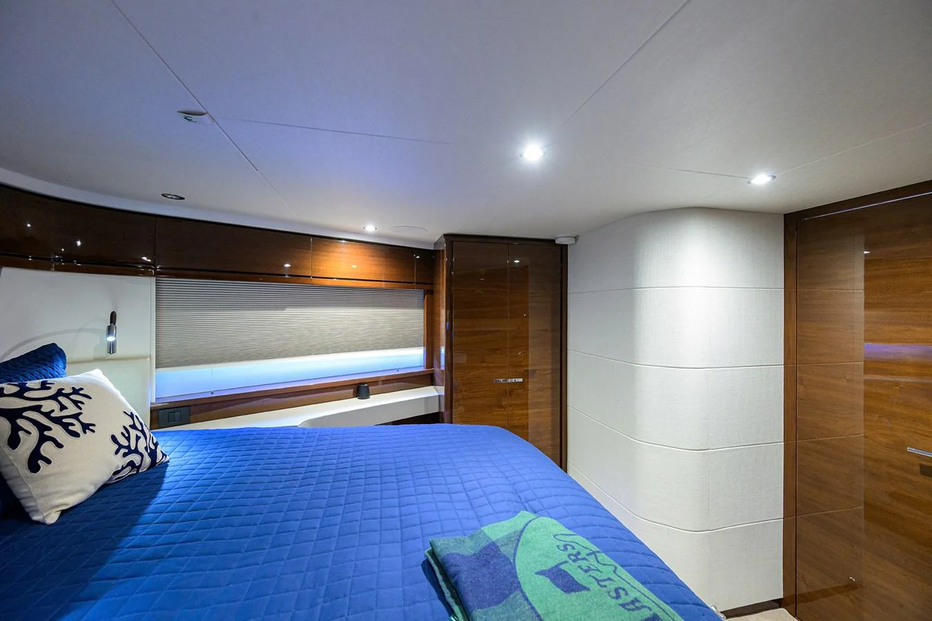 The guest stateroom features a cozy bed with elegant wood paneling and modern lighting. aboard MISS AMY Yacht for Sale