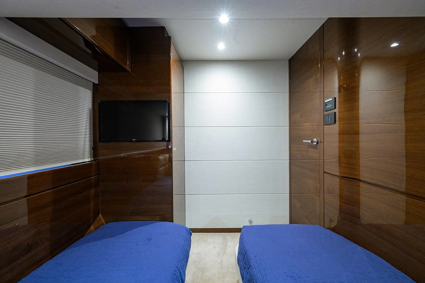 This cozy twin stateroom features sleek wood paneling and modern lighting. aboard MISS AMY Yacht for Sale