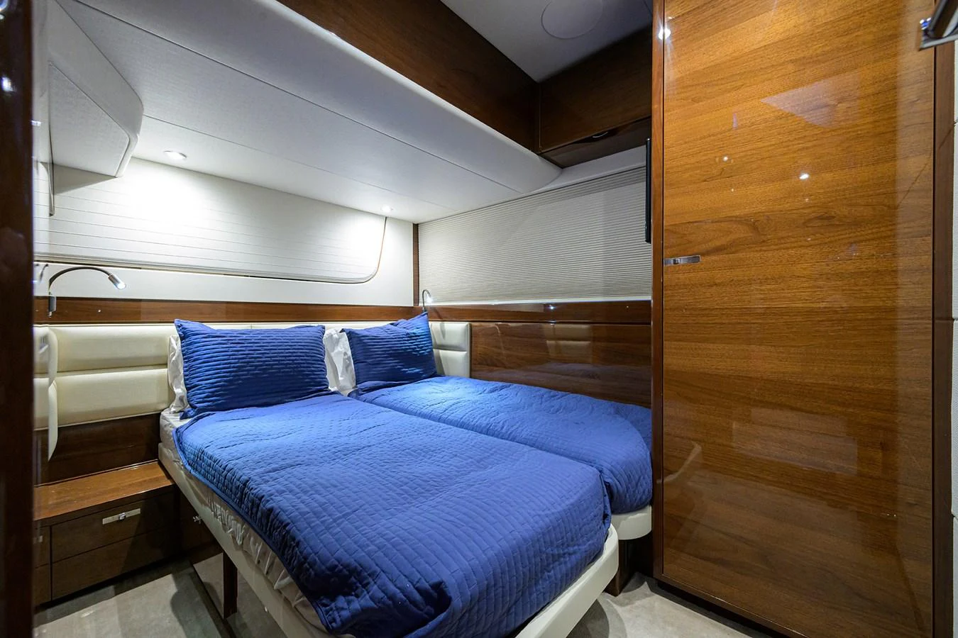 The stateroom features twin beds with rich wood paneling and modern lighting. aboard MISS AMY Yacht for Sale