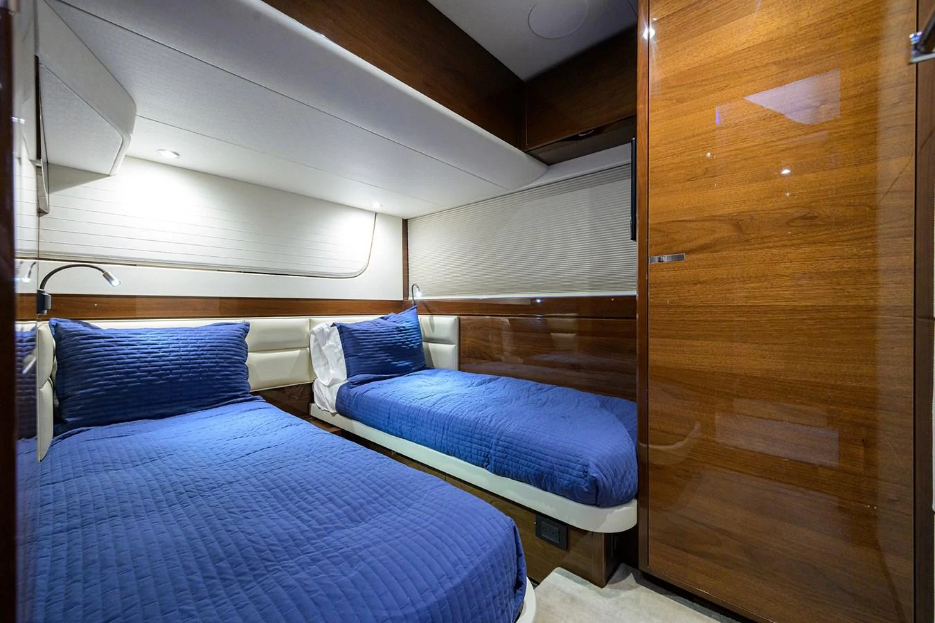 The guest stateroom features two twin beds with blue bedding and elegant wood paneling. aboard MISS AMY Yacht for Sale