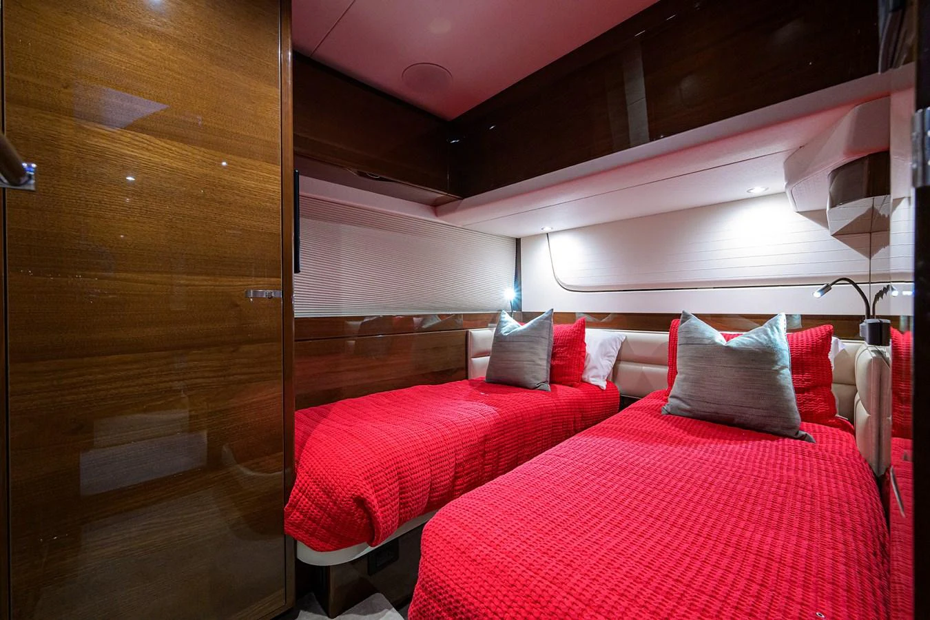 The twin stateroom features two single beds with vibrant red bedding and plush pillows, creating a cozy and inviting atmosphere. aboard MISS AMY Yacht for Sale