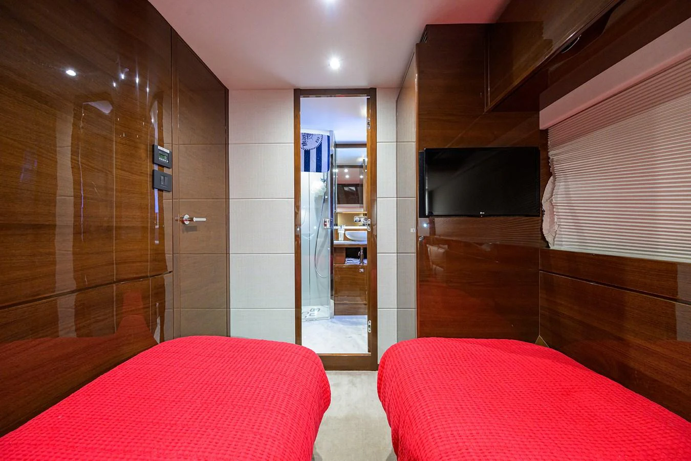 The guest cabin features twin beds with vibrant red bedding and a sleek, modern design. aboard MISS AMY Yacht for Sale