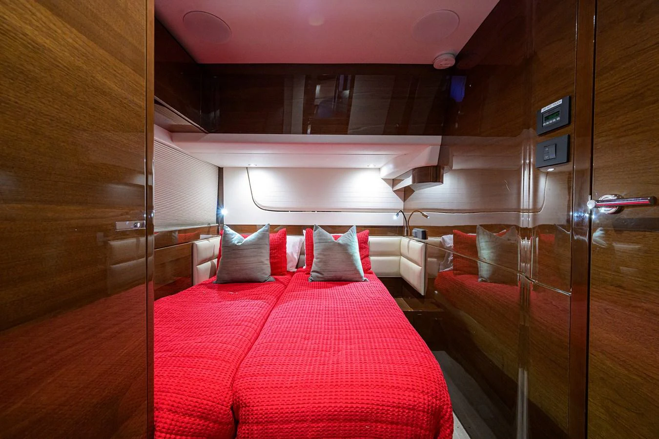 The stateroom features twin beds with vibrant red bedding and polished wood paneling. aboard MISS AMY Yacht for Sale