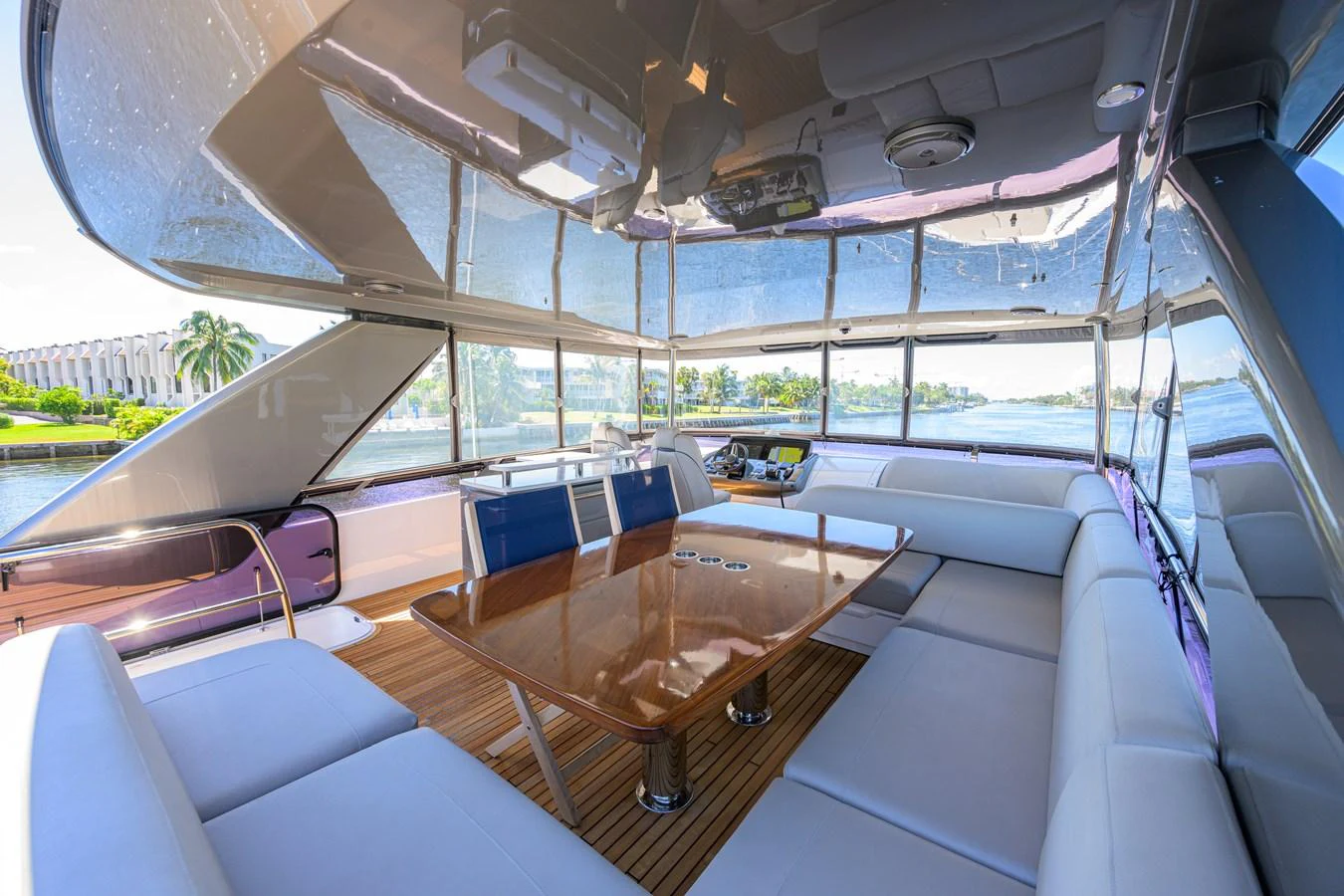 The yacht's salon features a spacious seating area with a large wooden table, surrounded by panoramic windows offering stunning views. aboard MISS AMY Yacht for Sale