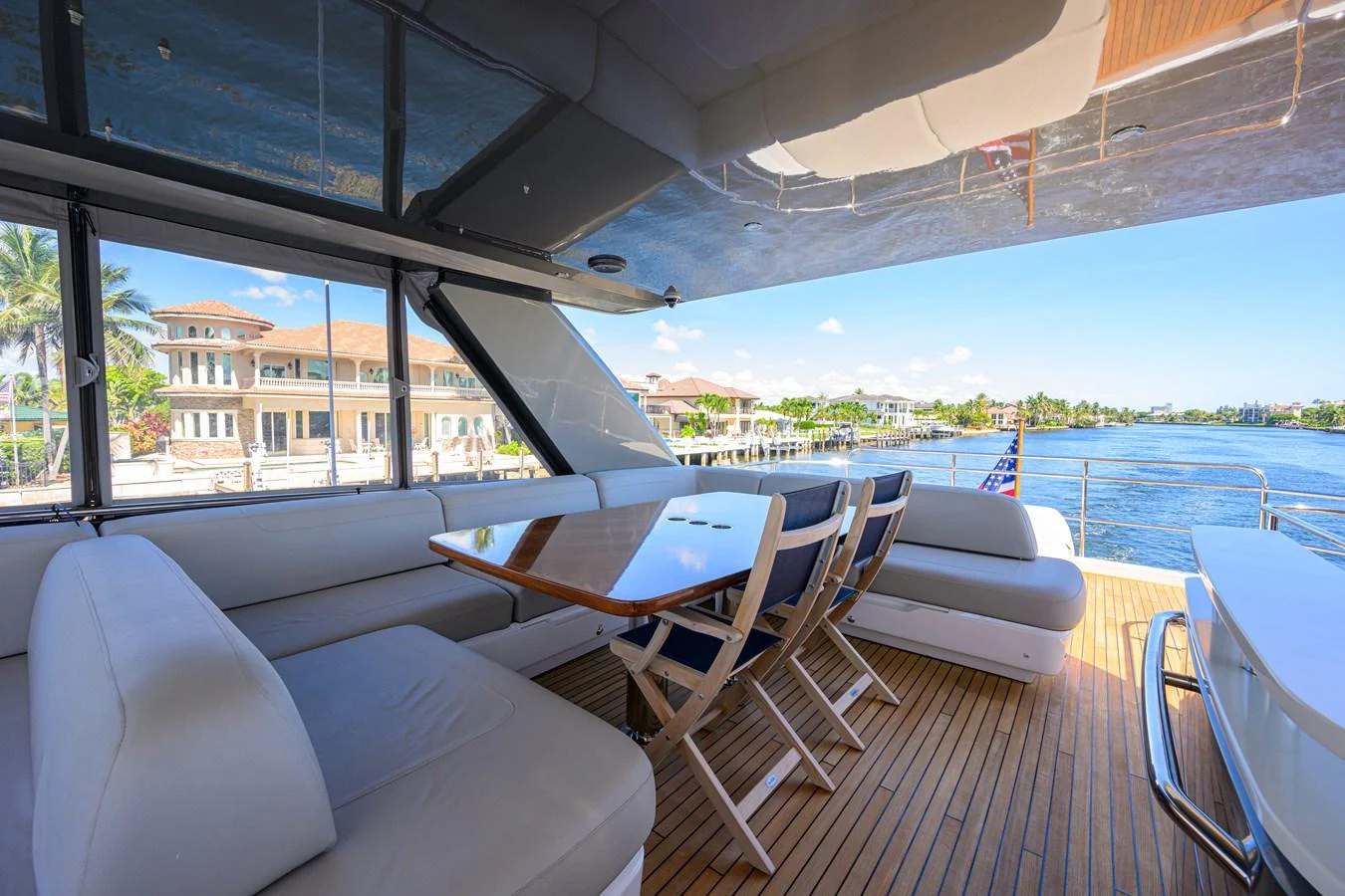 The aft deck features a spacious seating area with a polished wooden table, perfect for alfresco dining with a view. aboard MISS AMY Yacht for Sale