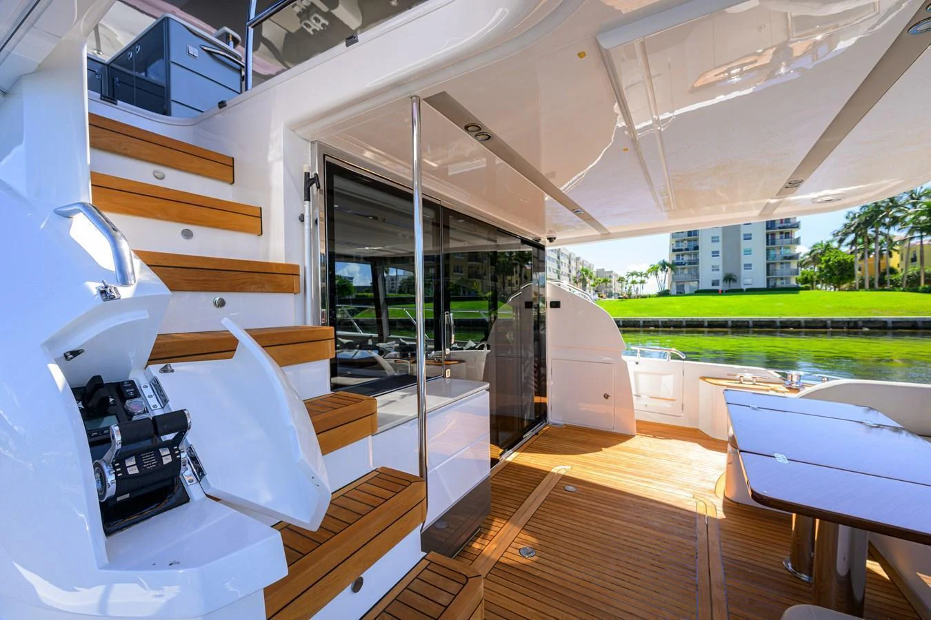 The aft deck features elegant wooden steps and a spacious seating area with a view of the water. aboard MISS AMY Yacht for Sale