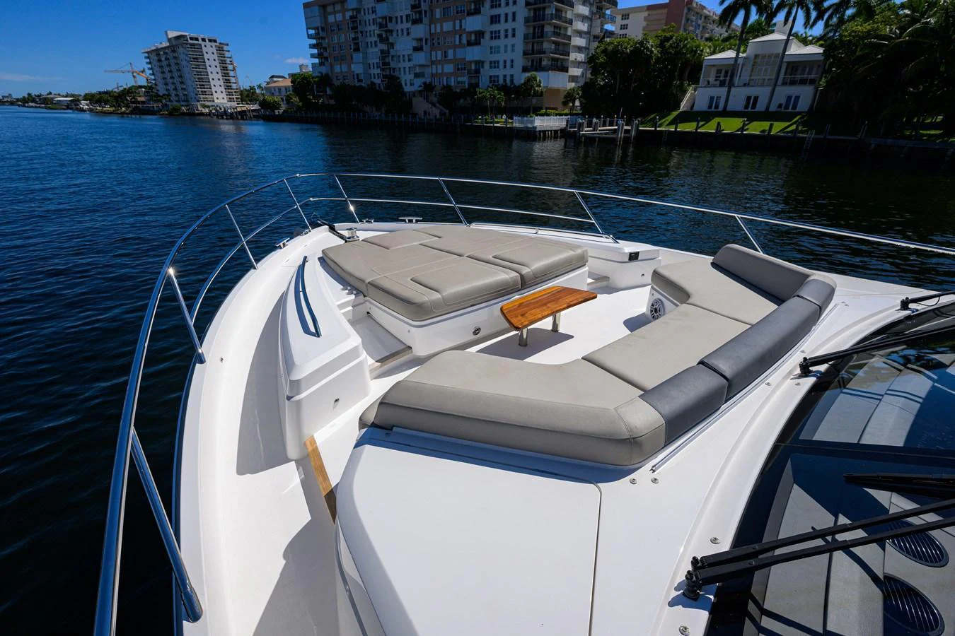 The yacht's foredeck features luxurious sun pads and a small wooden table, perfect for relaxation and enjoying the view. aboard MISS AMY Yacht for Sale