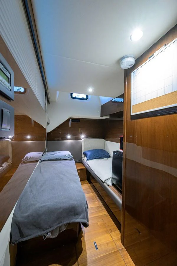A cozy cabin with twin beds and modern wooden finishes. aboard MISS AMY Yacht for Sale