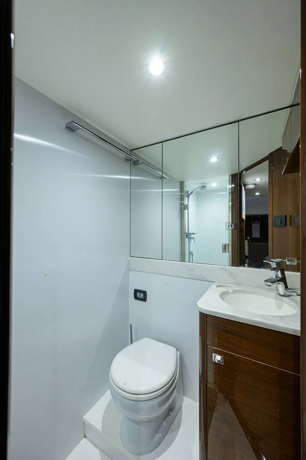 A sleek and modern yacht bathroom featuring a toilet, sink, and mirrored cabinets. aboard MISS AMY Yacht for Sale