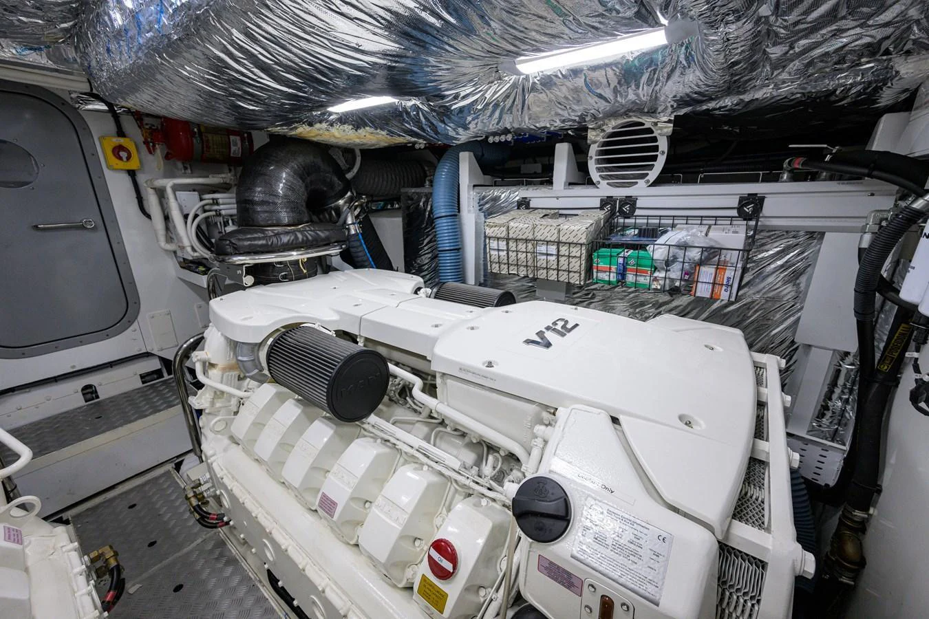 The yacht's engine room showcases a powerful V12 engine surrounded by meticulously organized equipment and reflective insulation. aboard MISS AMY Yacht for Sale