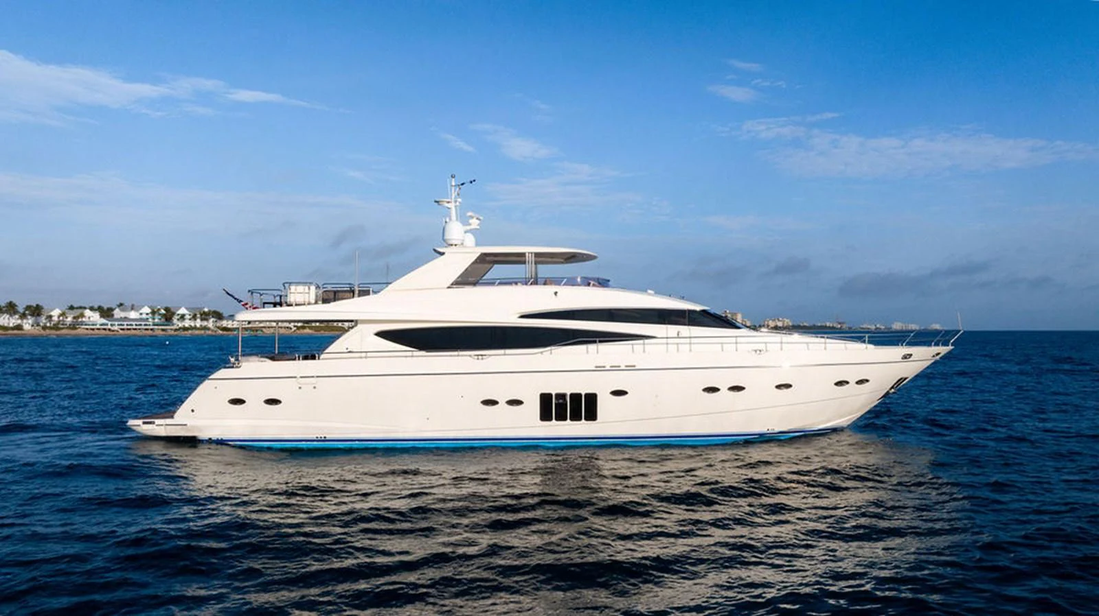 A sleek and modern yacht glides gracefully on the open water under a clear blue sky. aboard OASIS Yacht for Sale