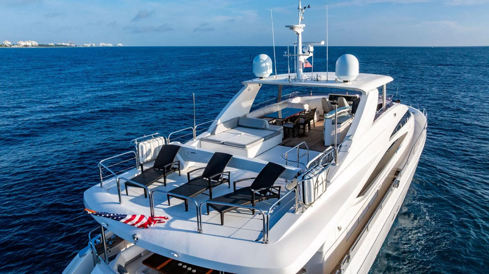 The yacht features a spacious sundeck with multiple lounging areas and a dining table, perfect for enjoying the open sea. aboard OASIS Yacht for Sale