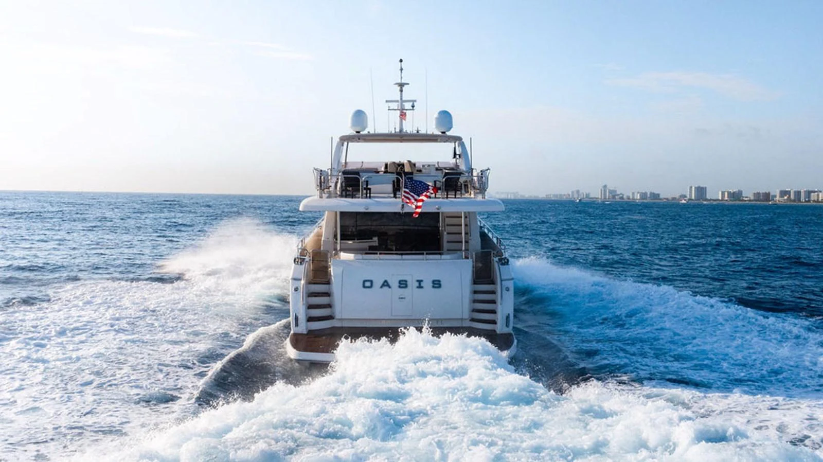 A luxurious yacht cruises through the open sea, leaving a trail of white water behind. aboard OASIS Yacht for Sale